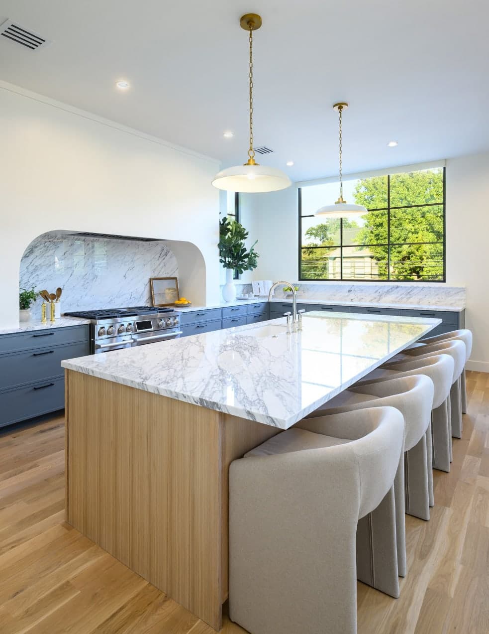Marble kitchen island beneath brass pendants at 4051 Hawthorne